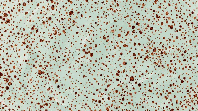 Hand-painted irregular brown speckles scattered across a pale blue-green textured surface
