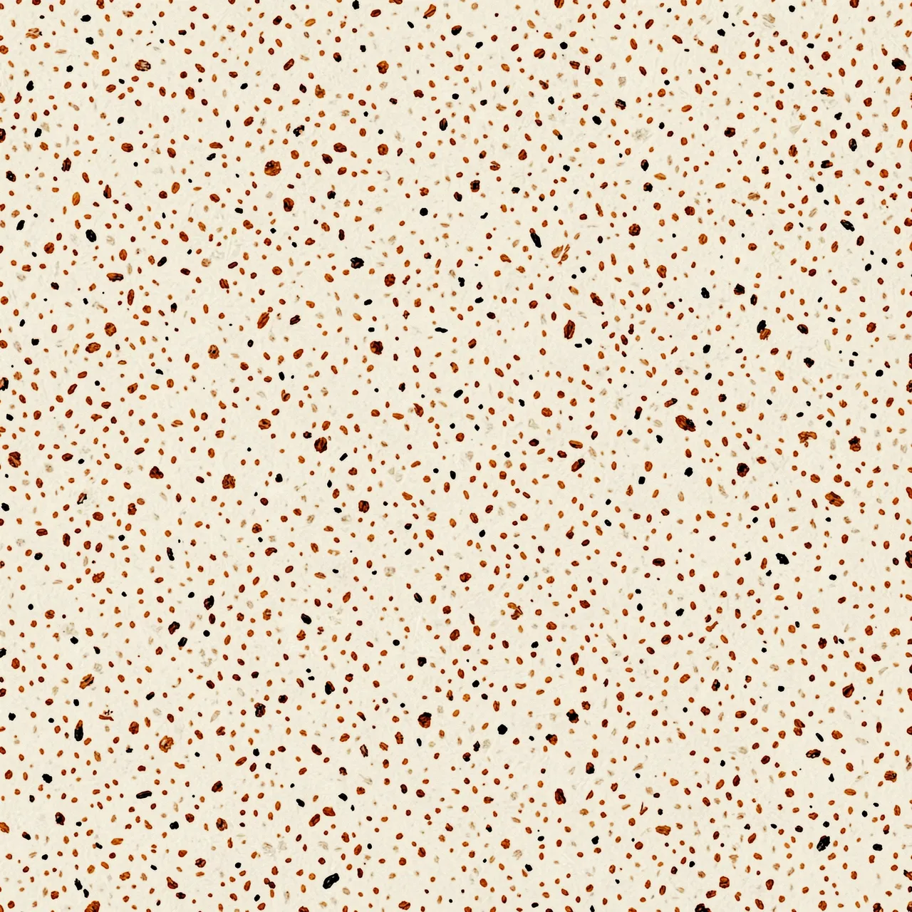 Tiny irregular brown and black flecks scattered across a warm off-white base