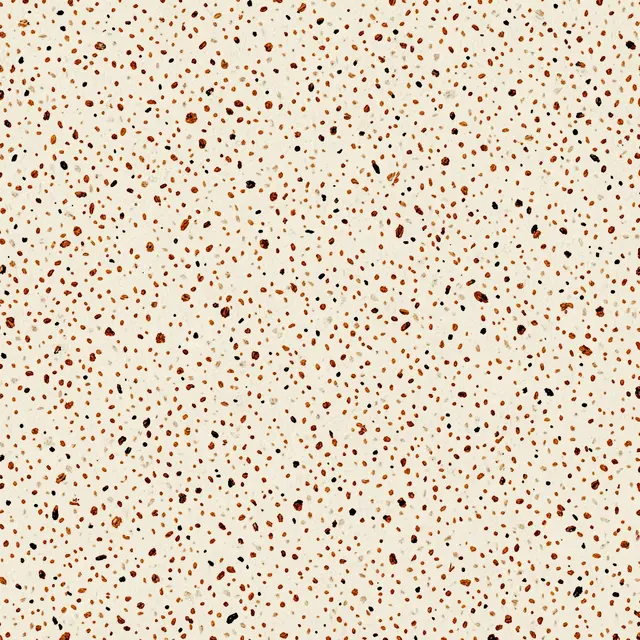 Tiny irregular brown and black flecks scattered across a warm off-white base