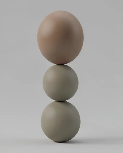 Three matte spheres stacked vertically in a balancing arrangement against a plain light gray background