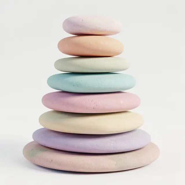 A neat vertical stack of smooth flat pastel pebbles against a plain light off-white background