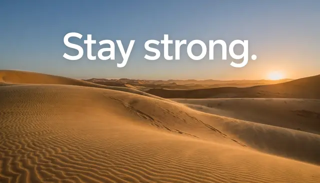 Wide desert dune sunset wallpaper with large white sans-serif text reading "Stay strong." over the sky
