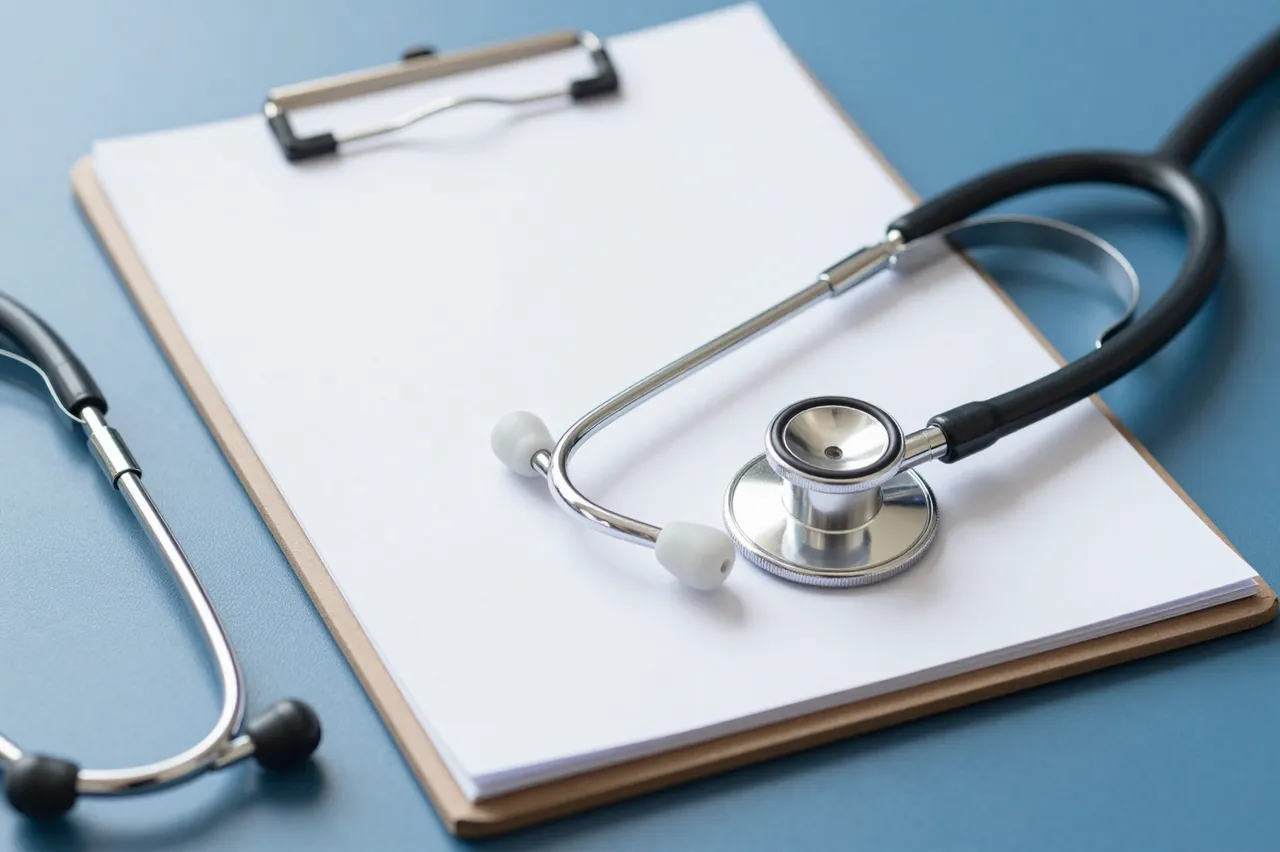 A stethoscope rests partially atop a blank paper clipboard on a smooth blue desk surface.