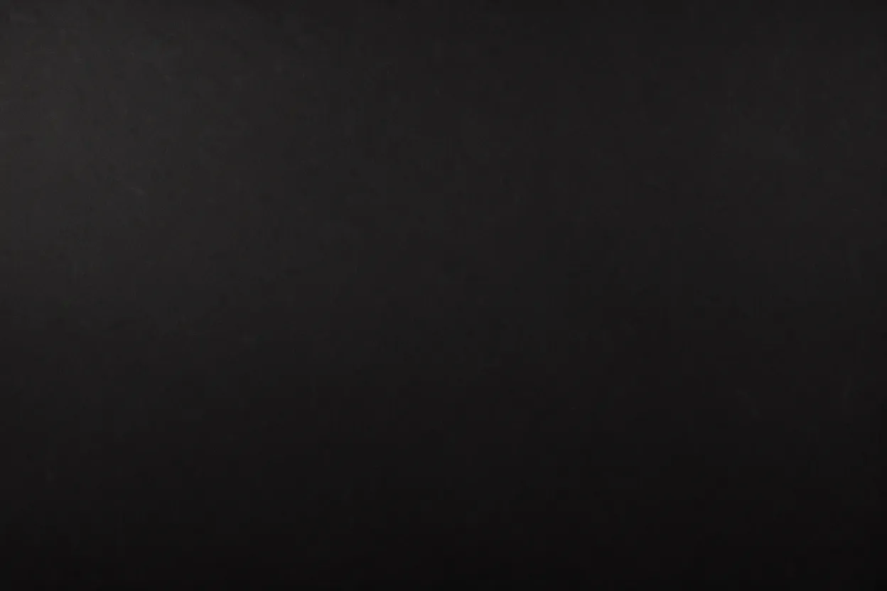 A full frame solid dark black surface with faint subtle grain texture