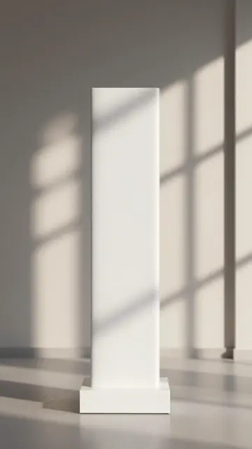 Tall white product plinth stands in a sunlit room with soft window shadow patterns across surfaces.
