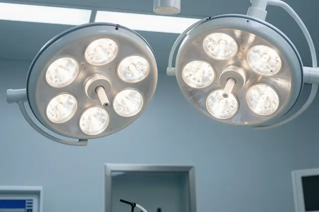 Low angle view of two illuminated round surgical ceiling lights in an empty operating room