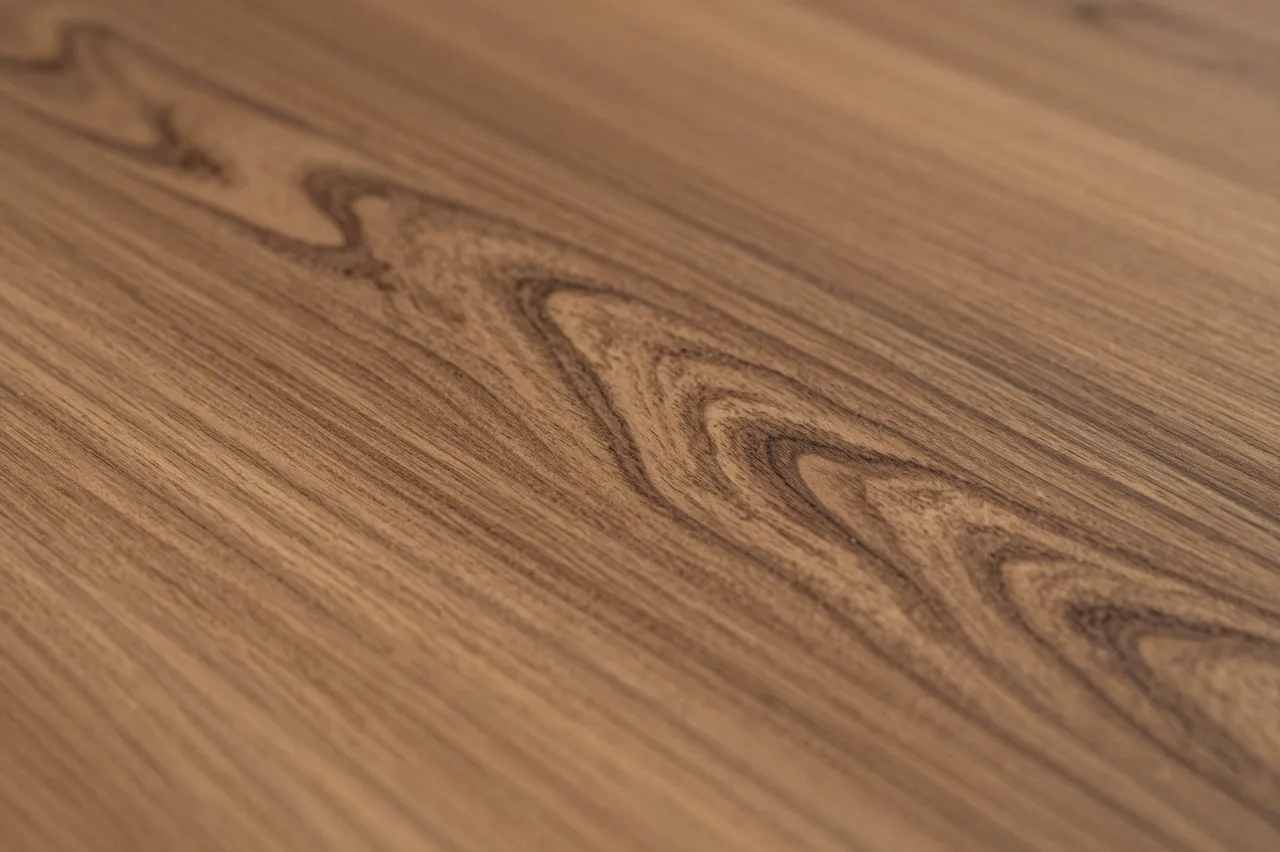 Close-up of polished olive wood surface with distinct swirling dark grain patterns