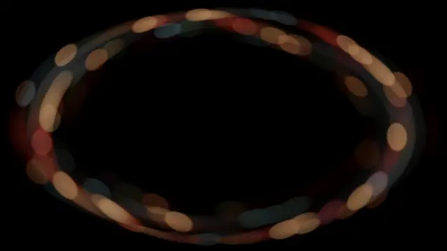Warm and cool oval bokeh lights form a swirling ring against a pure black background