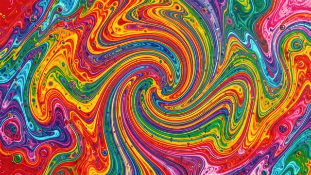 Vibrant swirling rainbow liquid crystal pattern viewed as a microscopic abstract texture