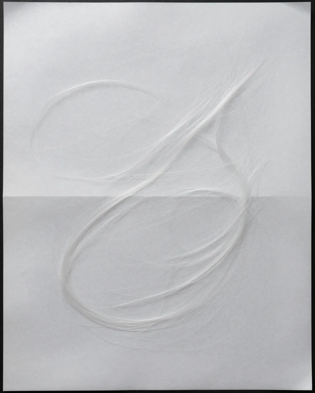 Translucent white backlit paper with long swirling embedded silk fibers filling the full frame
