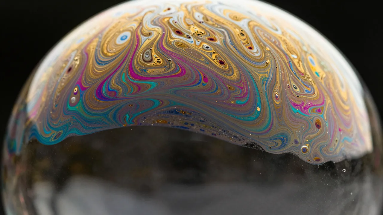 Close-up macro view of iridescent swirling thin-film patterns on a soap bubble against a black background