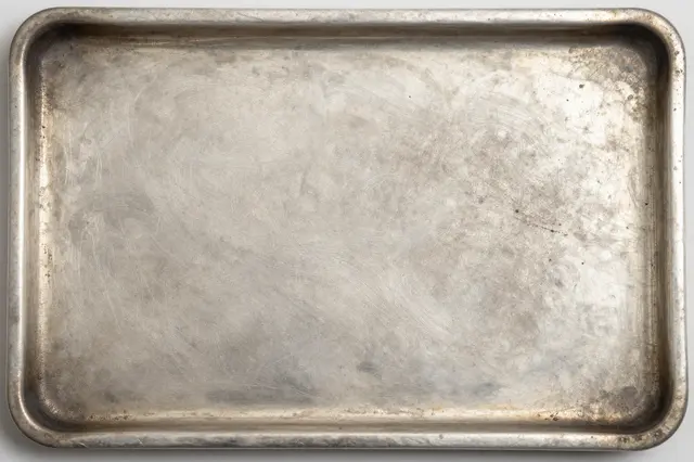 Top view full frame of a worn oxidized silver tray with dark tarnish in recessed edges and flat even lighting