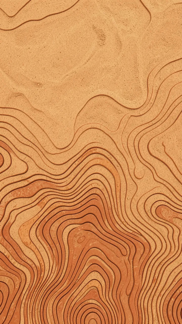 Carved terracotta topographic contour lines on warm sand with dense lines at the bottom and empty space above.