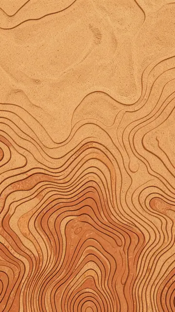 Carved terracotta topographic contour lines on warm sand with dense lines at the bottom and empty space above.