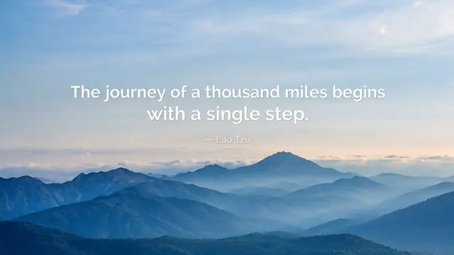 Dawn misty blue mountain range with the quote "The journey of a thousand miles begins with a single step" overlaid in white