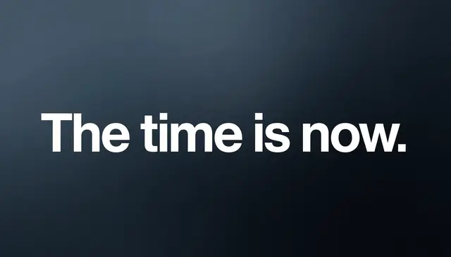 Bold white sans-serif text reading "The time is now." centered on a smooth dark slate gradient desktop wallpaper.