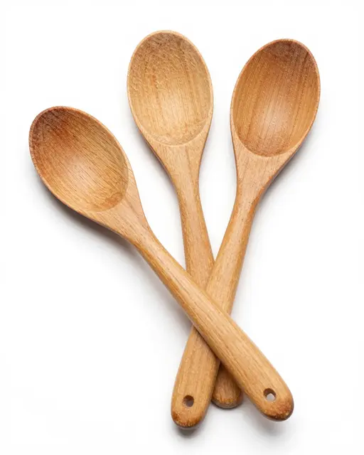 Three fanned wooden cooking spoons rest on a solid pure white background in a studio product shot