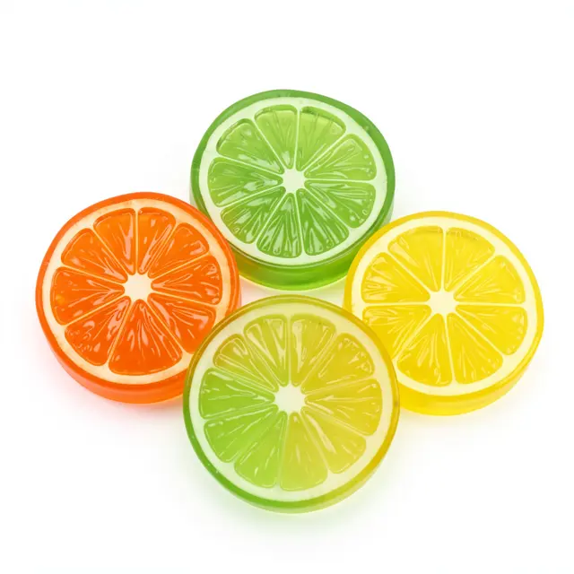 Four glossy translucent gummy citrus slices rest on a plain white background.