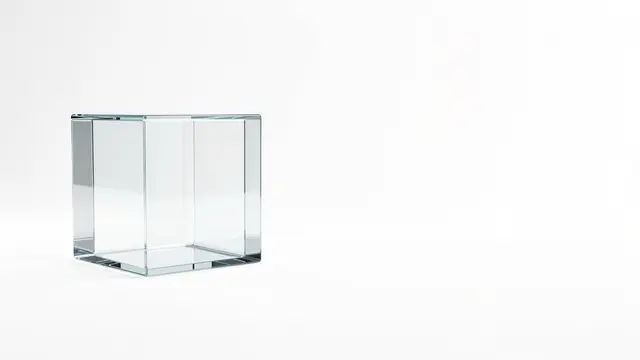 An empty transparent glass cube sits on the left of a plain white background with wide empty copy space to the right