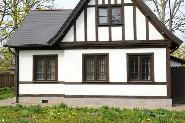 Half-timbered tudor house with a budding spring front garden under pale daylight