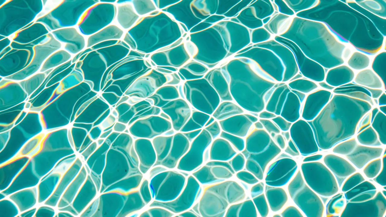 Shimmering wavy water caustics with iridescent rainbow fringes over bright turquoise pool water