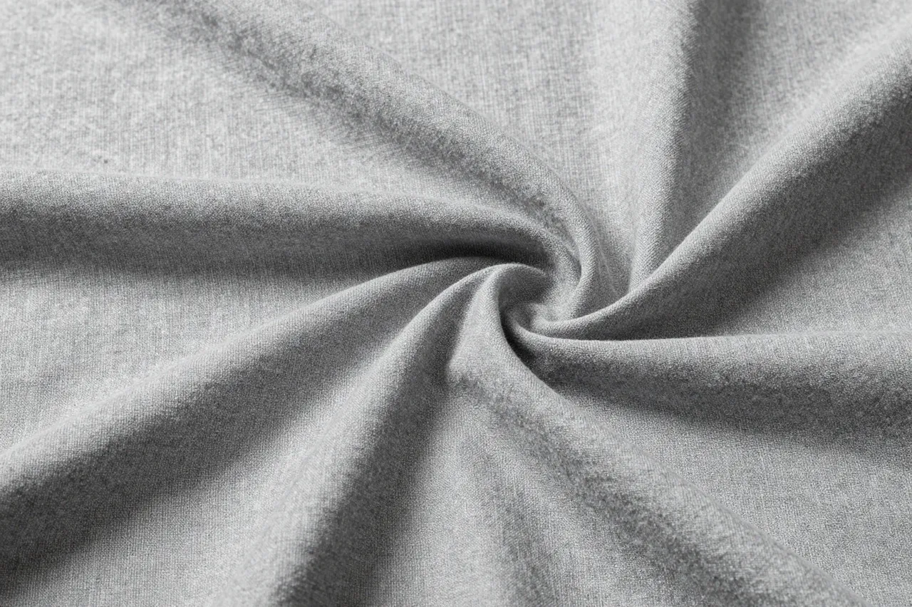 Close-up of softly wrinkled washed gray linen fabric twisted into a spiral center.