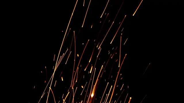Long exposure streaks of glowing orange embers rise upward against a solid pure black background