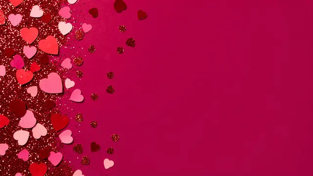 Red glitter and multi-toned heart confetti sit on the left of a deep pink backdrop with empty copy space on the right.