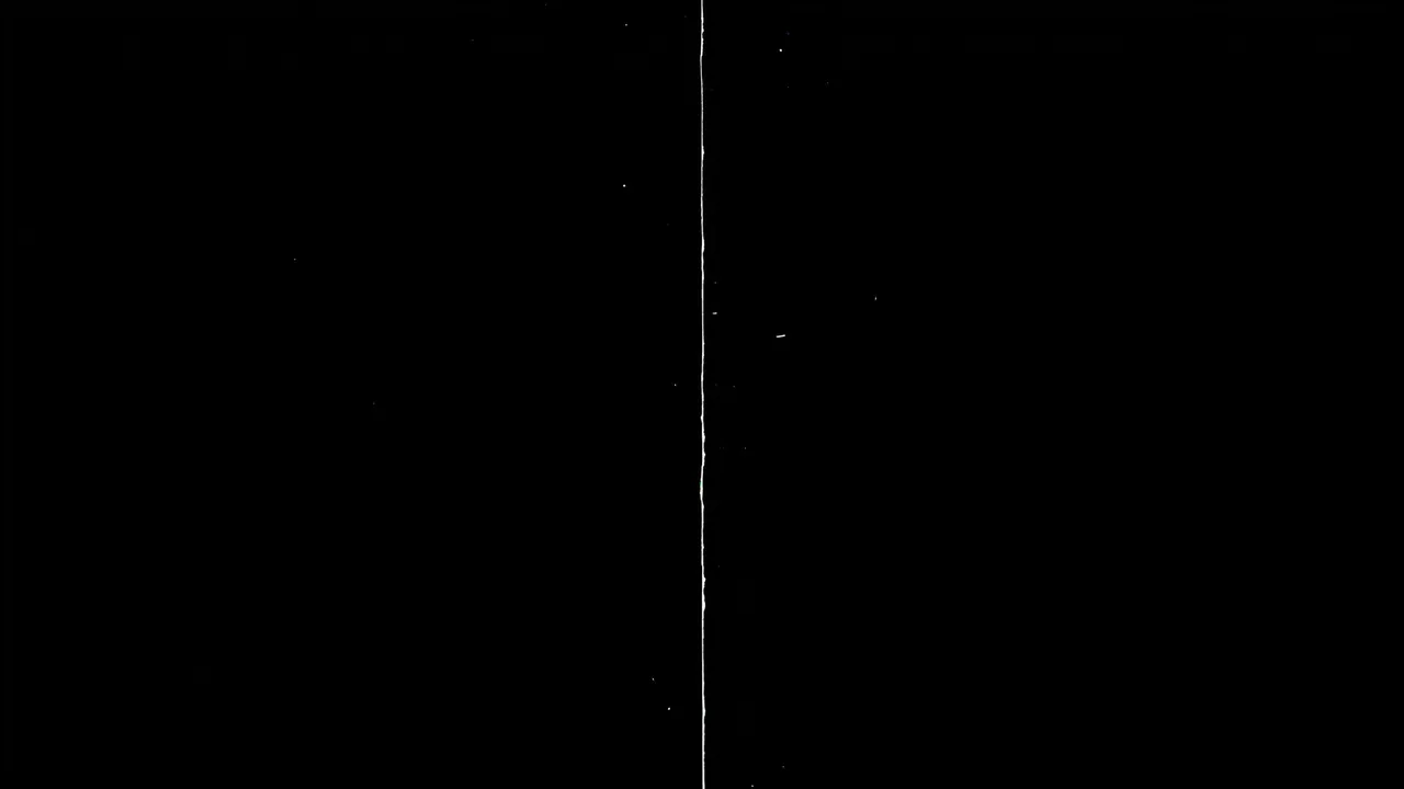 A thin vertical top-to-bottom film scratch with faint white specks sits on a solid pure black background
