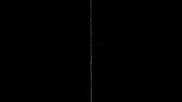 A thin vertical top-to-bottom film scratch with faint white specks sits on a solid pure black background