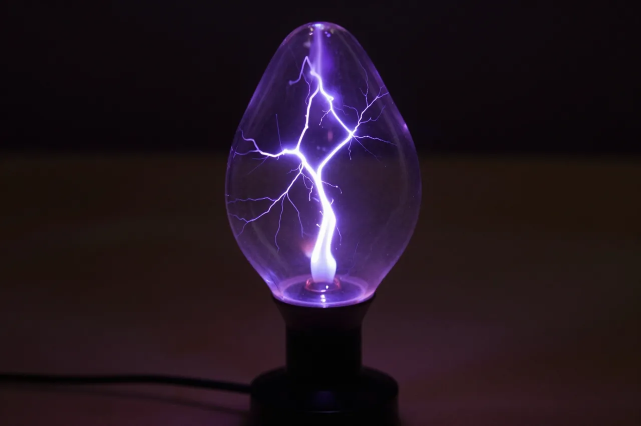 A plasma lamp with branching violet lightning filaments glows against a dark blurred background.
