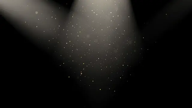 Soft warm volumetric light beams hold floating dust motes against a solid black background