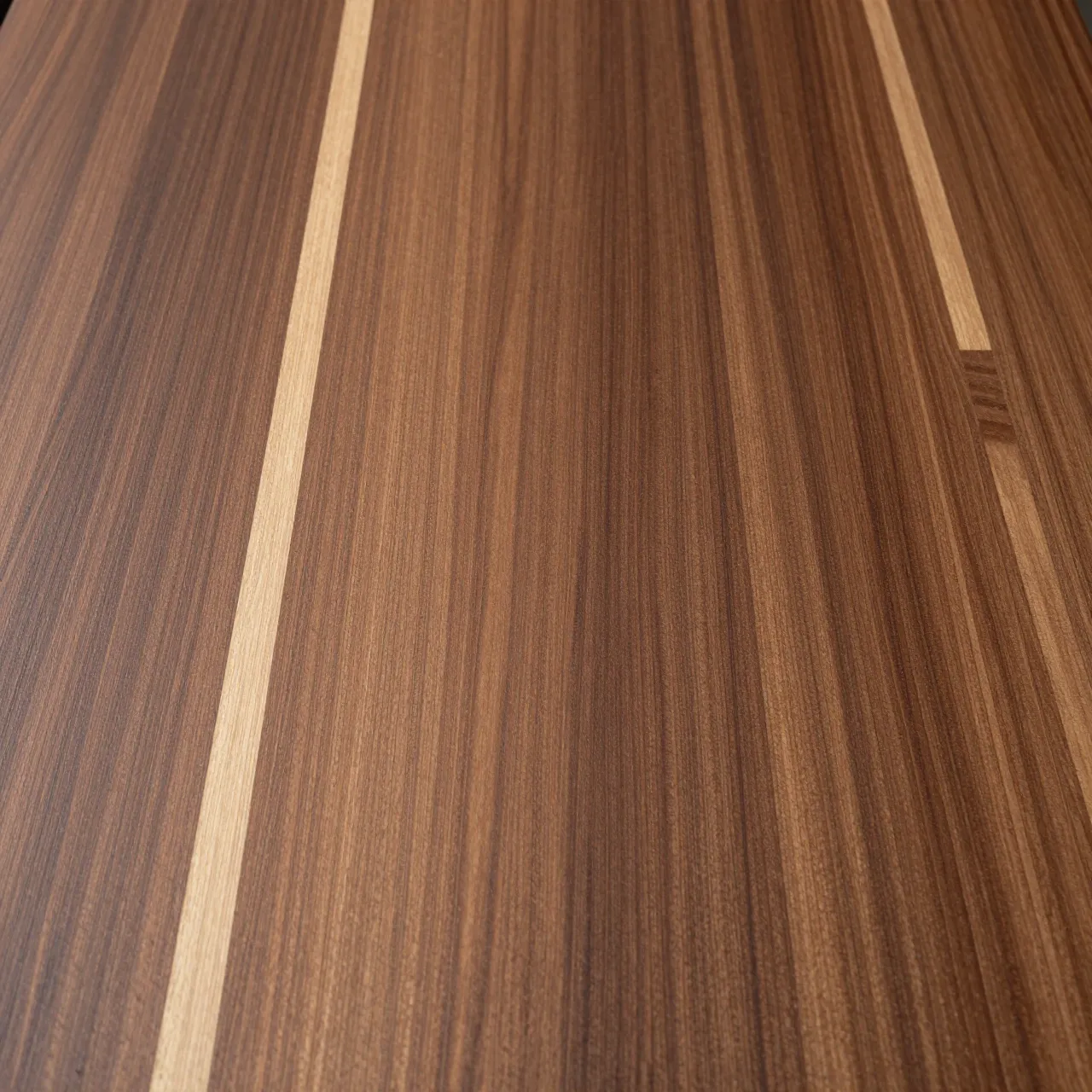 Full frame close-up of a flat walnut wood surface with rich grain and pale sapwood streaks.