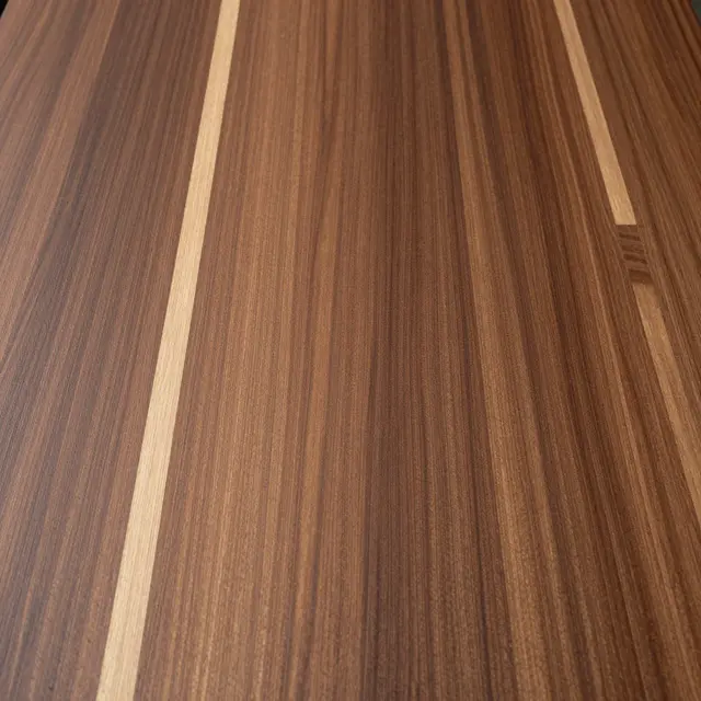 Full frame close-up of a flat walnut wood surface with rich grain and pale sapwood streaks.