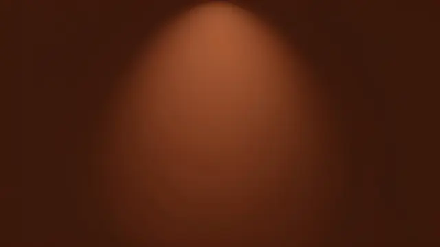 A smooth chocolate brown background with a soft warm spotlight glowing in the center