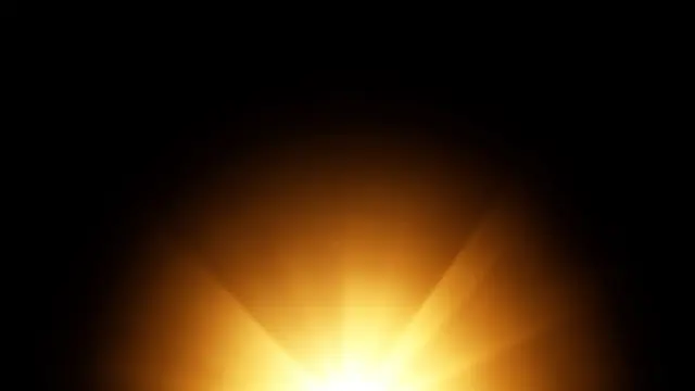 Soft golden lens flare bursts upward from the bottom edge against a pure black background