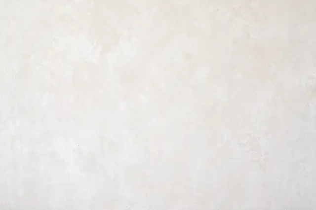 Full frame close-up of a matte warm white limewash wall with soft cloudy brush strokes