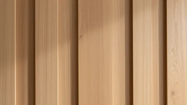 Close-up of vertical warm oak slats with soft recessed vertical shadows across the surface