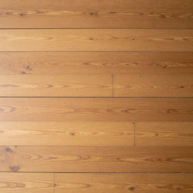 Top view full frame of worn amber horizontal pine floorboards covering the entire frame