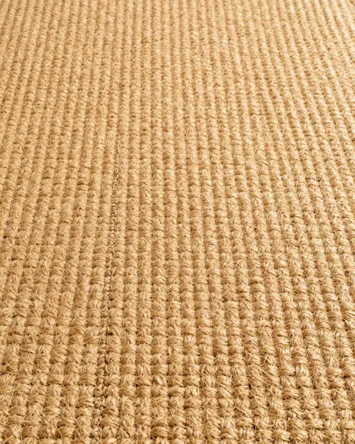 Full frame top view of coarse ribbed woven warm golden tan sisal carpet