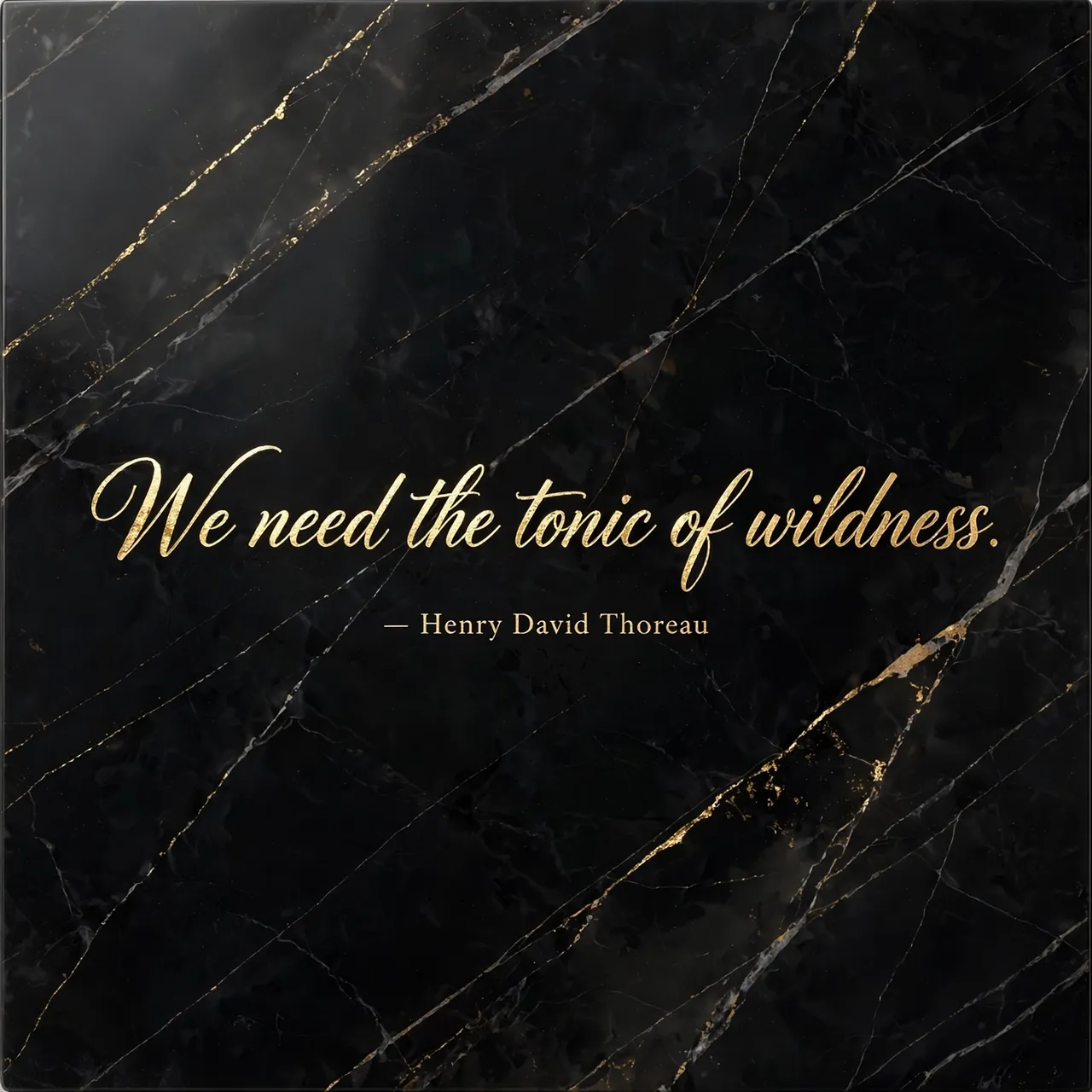 Gold foil script quote "We need the tonic of wildness. — Henry David Thoreau" set on polished black marble with gold veining