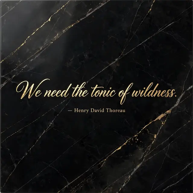 Gold foil script quote "We need the tonic of wildness. — Henry David Thoreau" set on polished black marble with gold veining
