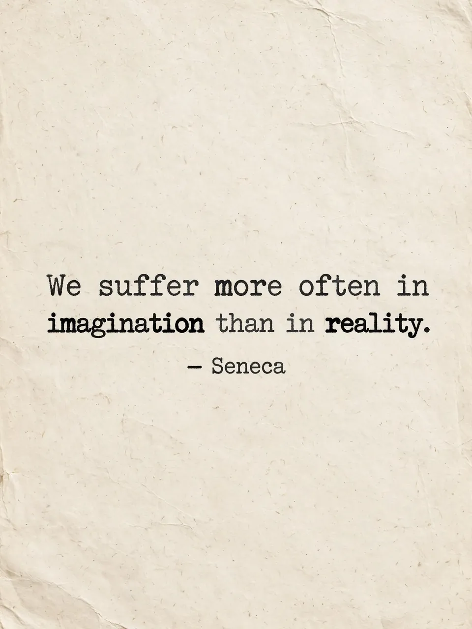 Typewritten quote "We suffer more often in imagination than in reality" by Seneca printed on crumpled warm off-white paper
