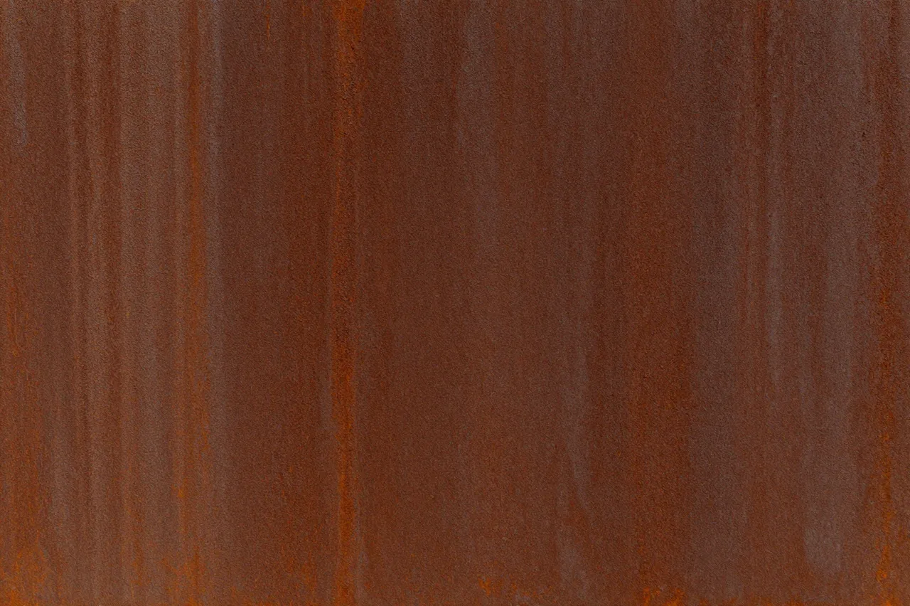 Full frame close-up of a deep rust brown weathered corten steel surface with subtle vertical streaks