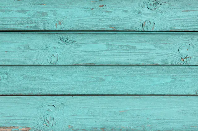 Full frame close-up of horizontal old wood planks with chipped worn turquoise paint