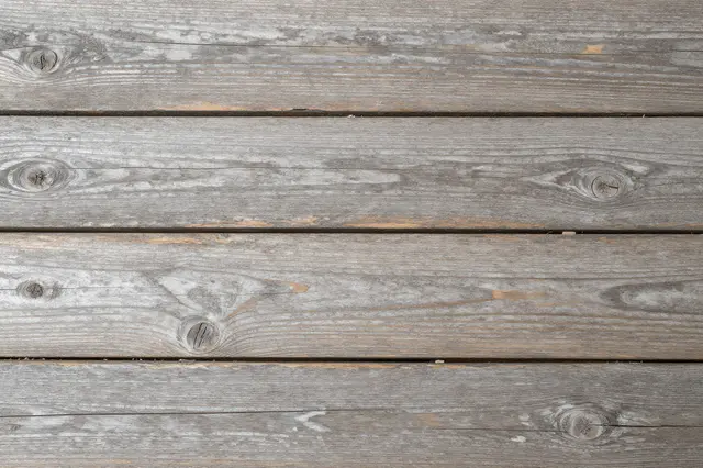 Top view of parallel weathered gray wooden planks with natural grain and knots