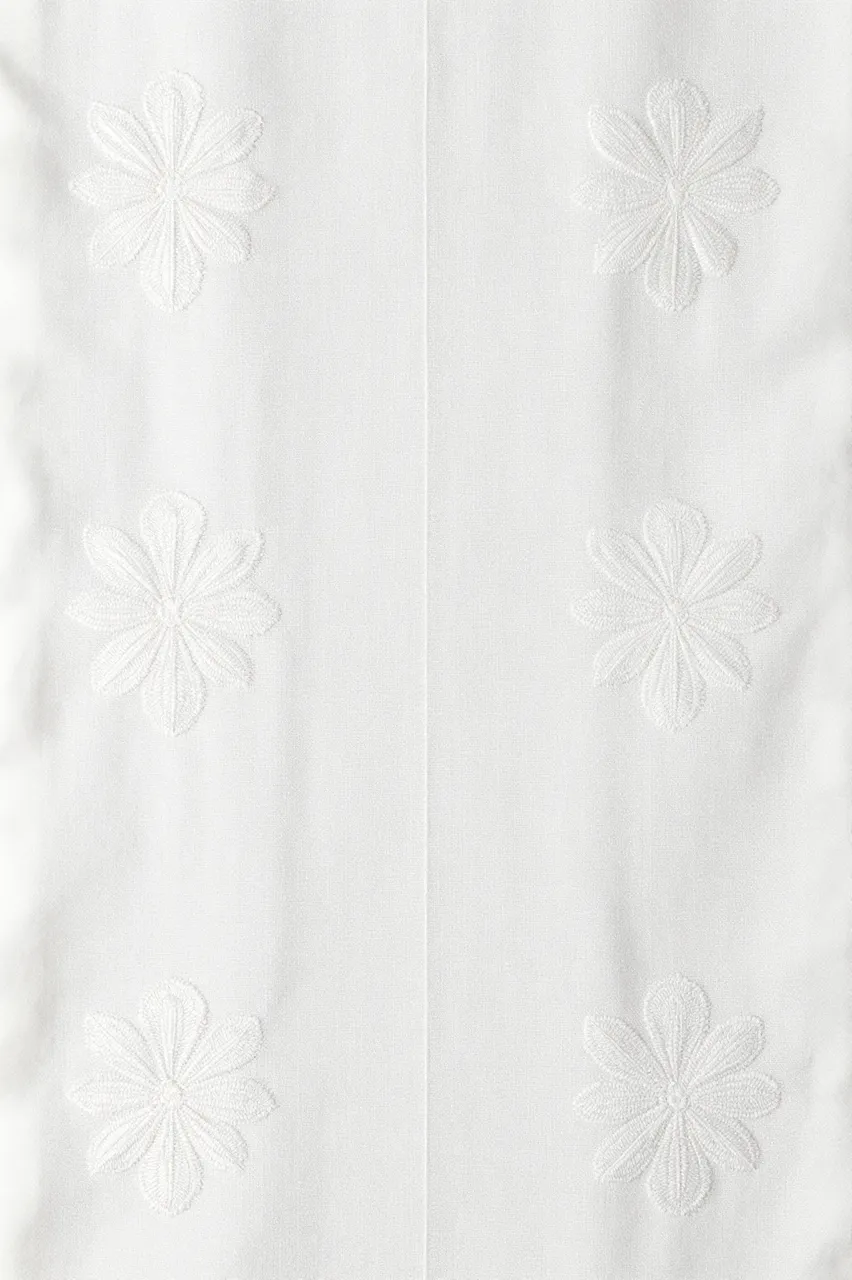 Full frame close up of tone-on-tone white floral embroidery stitched onto textured white linen fabric