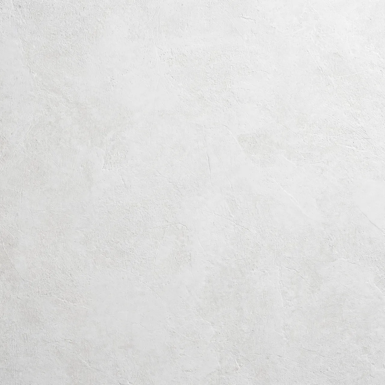 Full frame close-up of a matte chalky white microcement wall with faint fine surface ridges