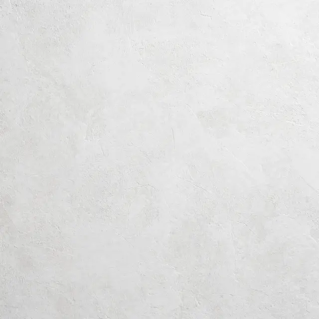Full frame close-up of a matte chalky white microcement wall with faint fine surface ridges