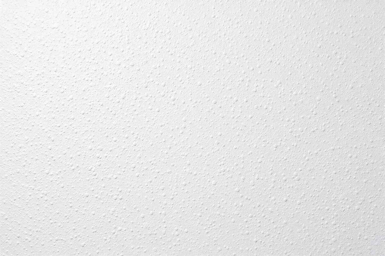 Full frame close-up of a white orange peel drywall finish with fine rounded raised bumps